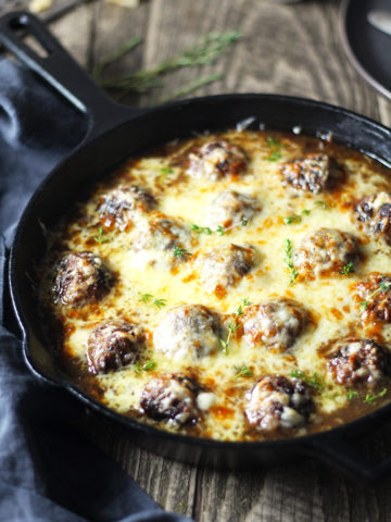 One skillet French Onion Cheese Stuffed Meatballs are the perfect alternative to soup! Meatballs stuffed with Swiss cheese and smothered in perfectly caramelized onion and red wine gravy.