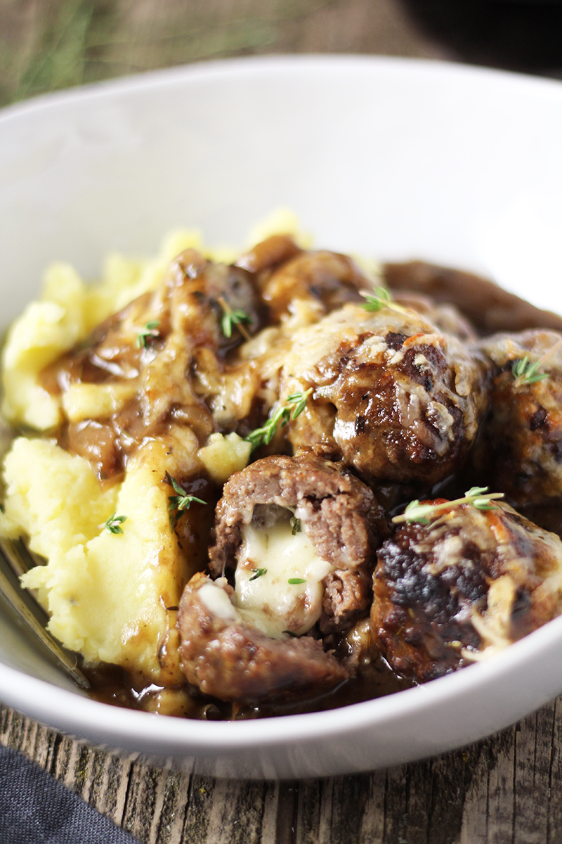 One skillet French Onion Cheese Stuffed Meatballs are the perfect alternative to soup! Meatballs stuffed with Swiss cheese and smothered in perfectly caramelized onion and red wine gravy.
