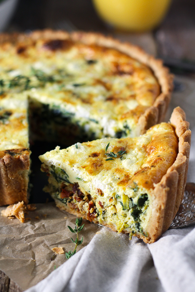 Deep-dish quiche packed with veggies and bursting with flavor! Tender and flaky crust filled with a fluffy egg center baked with sautéed leeks and spinach, sun-dried tomatoes, and creamy goat cheese.