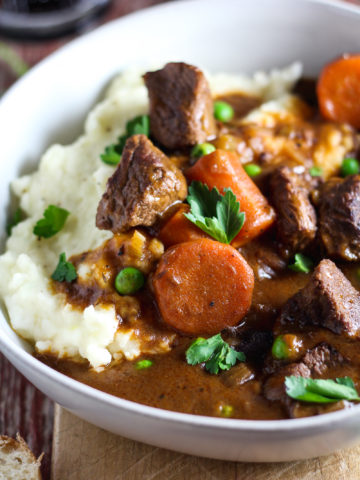 Insanely tender, fall-apart beef, carrots and peas smothered in rich gravy made with Jameson whiskey and Guinness beer. This stew packs incredible flavor and is served over creamy garlic mashed potatoes, making it the ultimate comfort food. Slow cooked in the crockpot, it’s easy to make and perfect for feeding a crowd on St. Patrick’s Day!