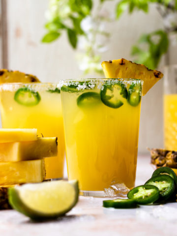 Refreshing and delicious pineapple margarita with a little kick of heat! This fun cocktail is perfect for sipping on a warm, sunny day, and is only lightly sweetened with pineapple juice. Add your desired level of spice by adding more or less jalapeño slices, or omit them if spicy isn't your thing. The cocktail will still taste great!