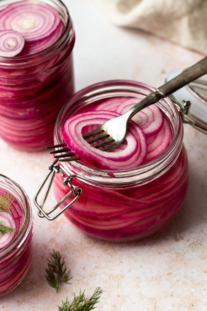Quick pickled onions are so easy to make and crazy flavorful! All you need is 5 simple ingredients and 10 minutes of time - no canning required! They are a a staple in our home. I always keep a jar or two easily accessible in the fridge. Quick pickled onions add so much flavor to your favorite foods - every kind of taco, burgers, brats, grain bowls and more!