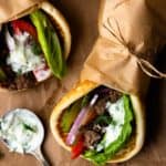 Easy Ground Beef Gyros are so delicious and ready in 30 minutes! Ground beef is perfectly seasoned with a greek spice blend then tucked inside of a soft pita with lots of fresh lettuce, tomato, cucumber, and red onion. Finish the gyro with homemade tzatziki sauce and feta cheese.