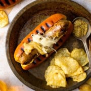 beer brat served with chips and beer