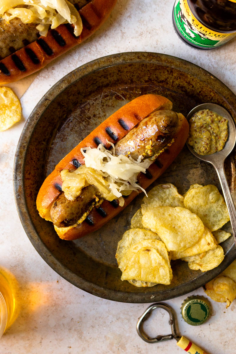 beer brat served with chips and beer