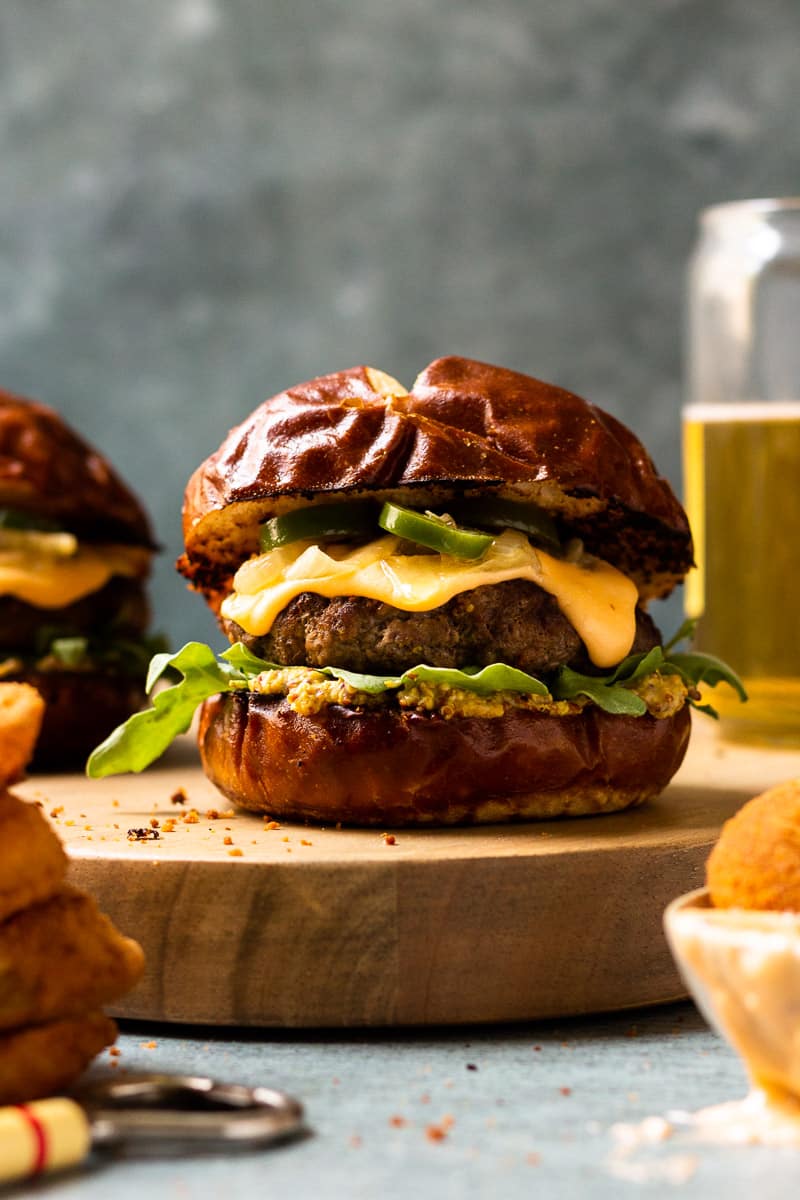 beer cheese burger on pretzel bun with caramelized onions