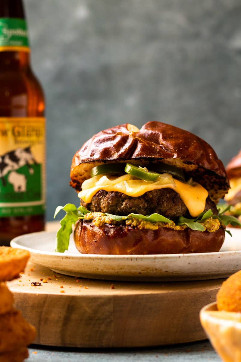 Beer Cheese Burgers on Pretzel Buns with Caramelized Beer Onions and Jalapeños - Modern Farmhouse Eats