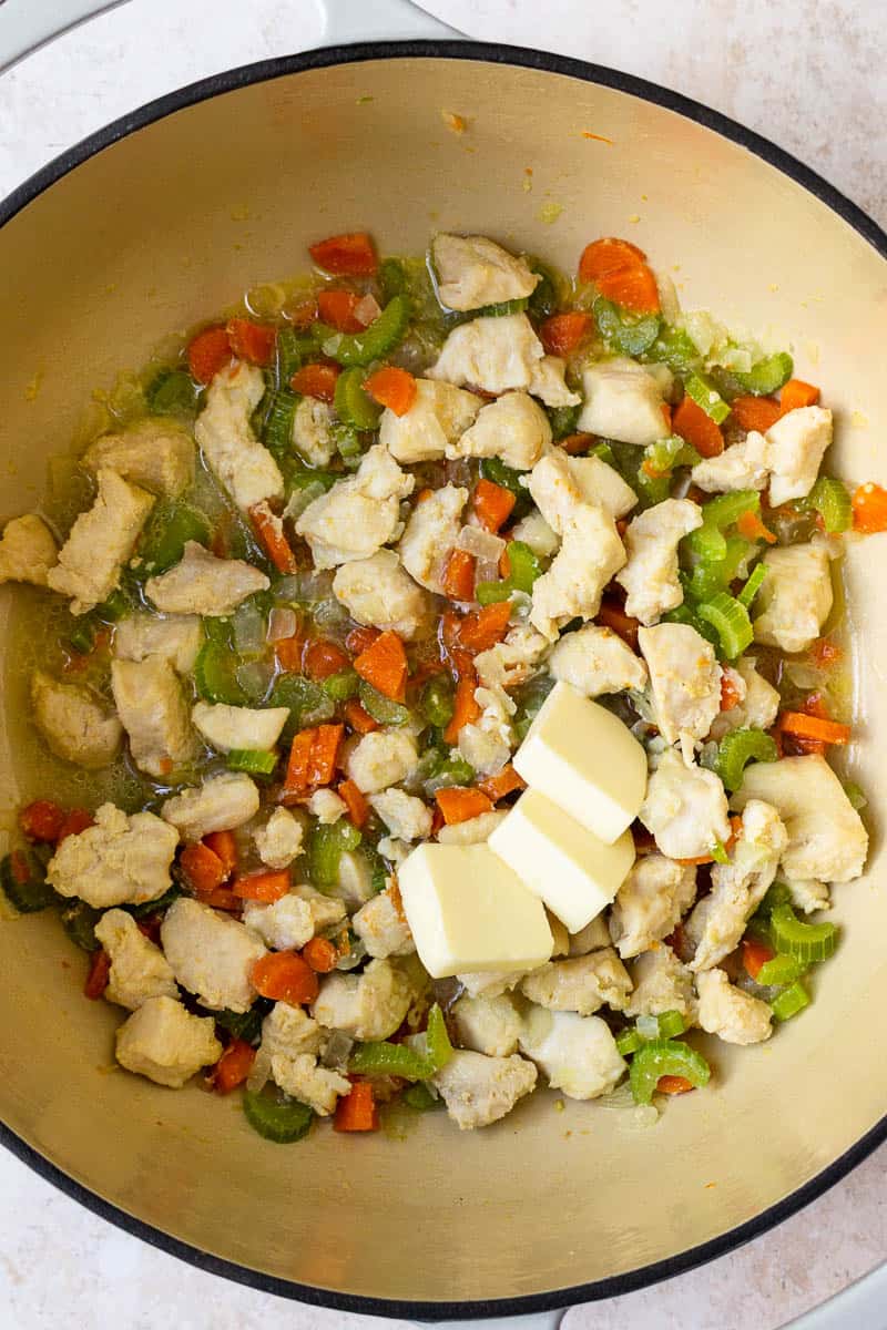 cooked chicken and vegetables in a pot with butter
