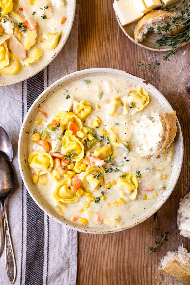 creamy chicken and cheese tortellini soup in a bowl with bread