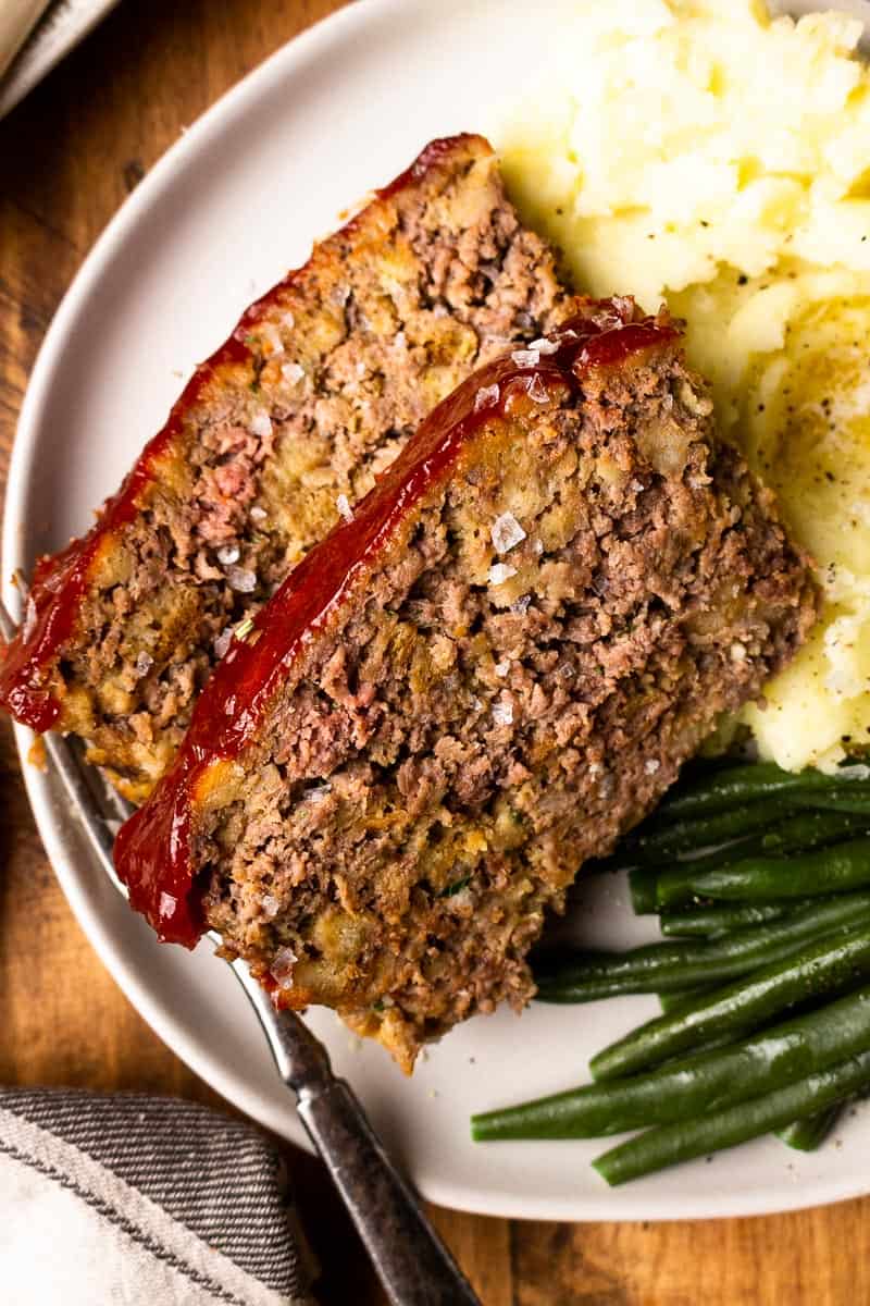 meatloaf stuffing on a plate with potatoes and green beans