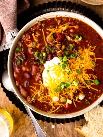 venison chili in a bowl with beer
