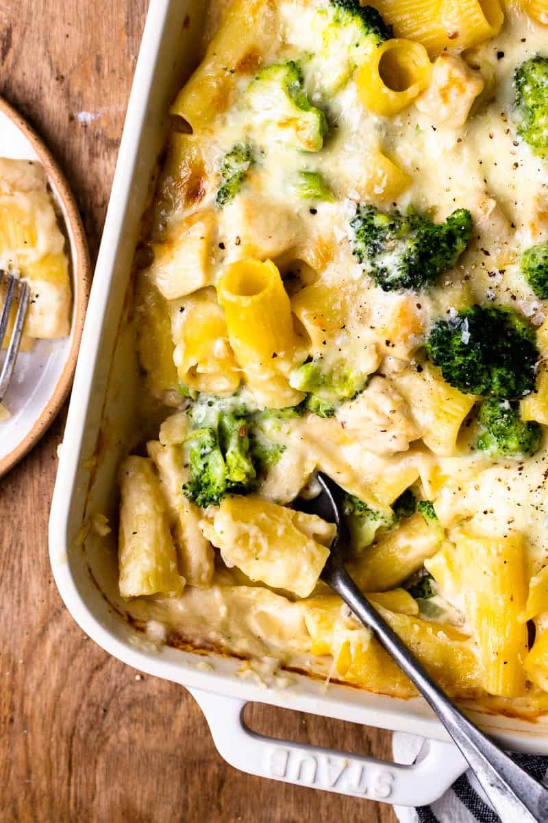 serving chicken and broccoli pasta bake onto a plate