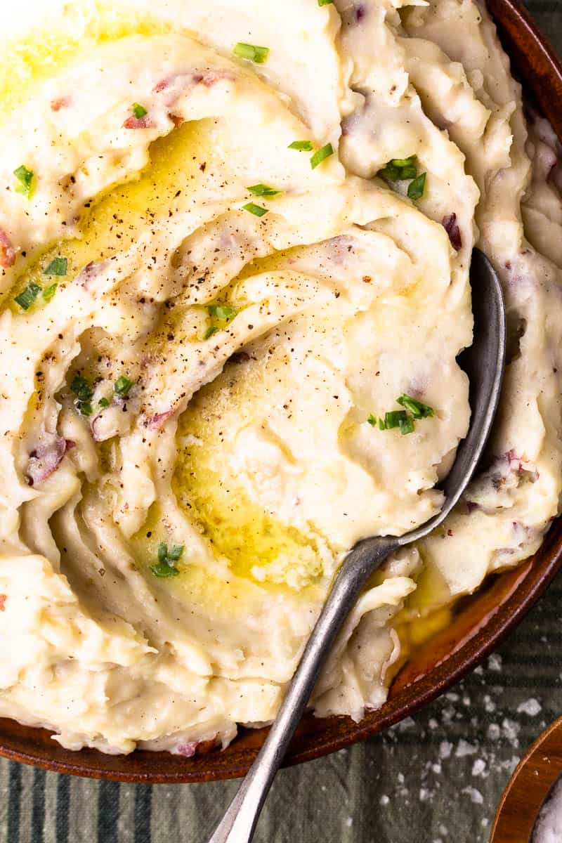 mashed potatoes in serving bowl with melted butter