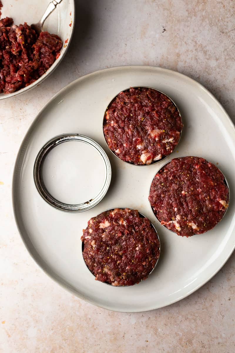 uncooked venison burger patties on a plate