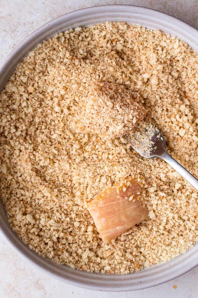 raw chicken pieces in bowl of breading