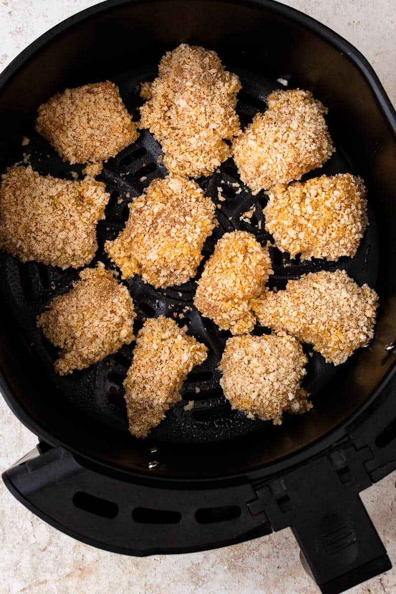 uncooked breaded chicken nuggets in air fryer basket
