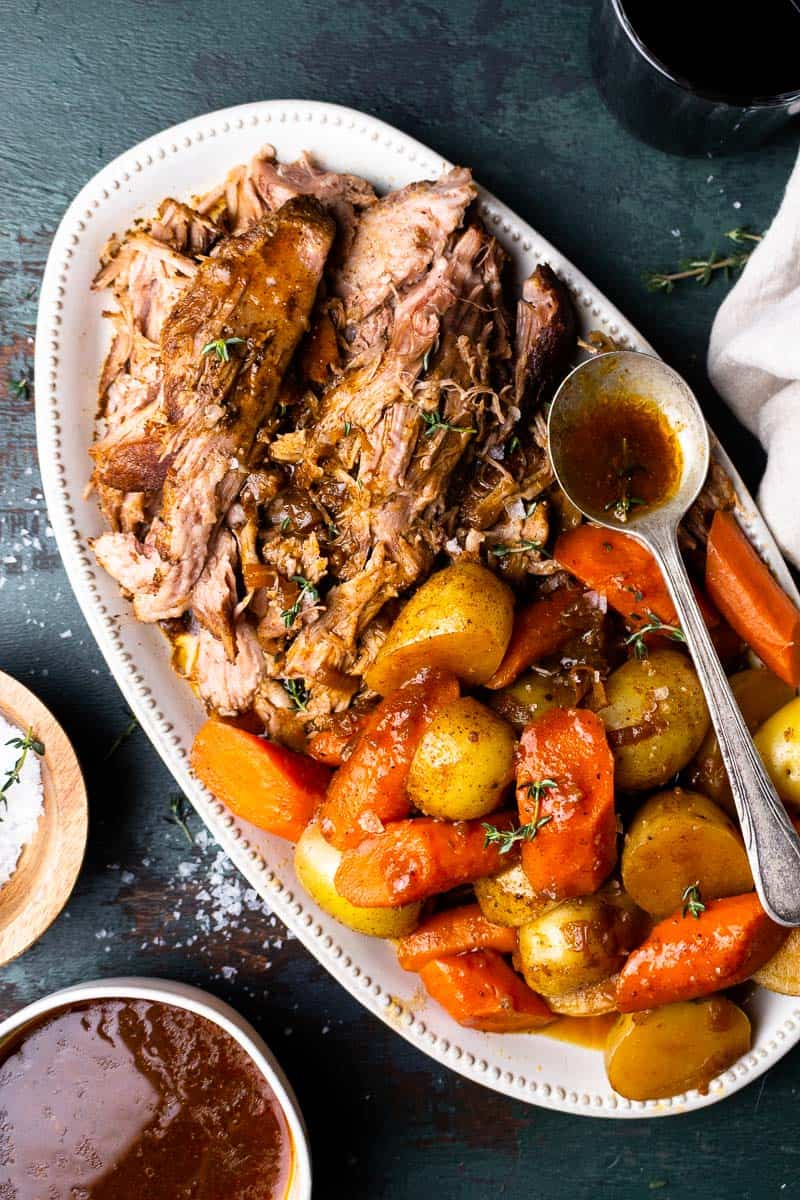 shredded pork roast on a serving plate with carrots and potatoes