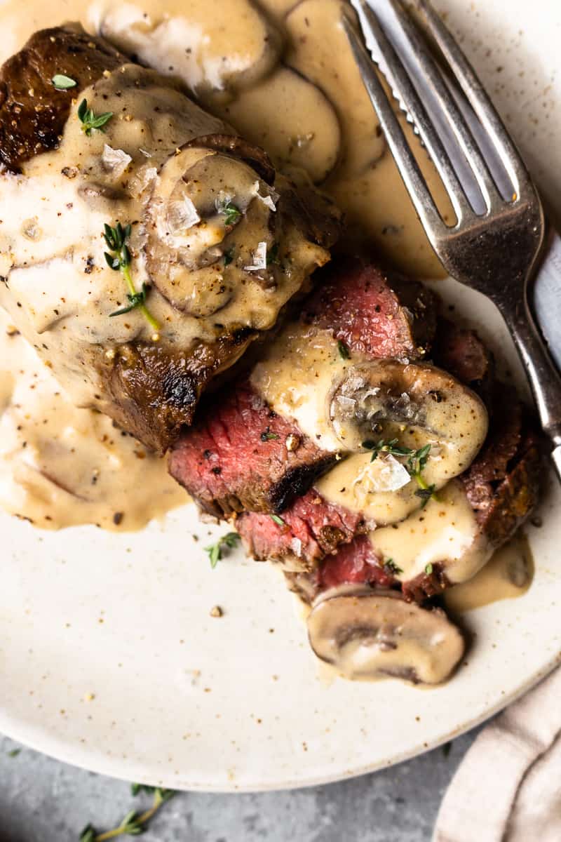 sliced venison steak covered in mushroom cream sauce
