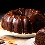 brownie cake on a serving dish with a slice of cake on a plate