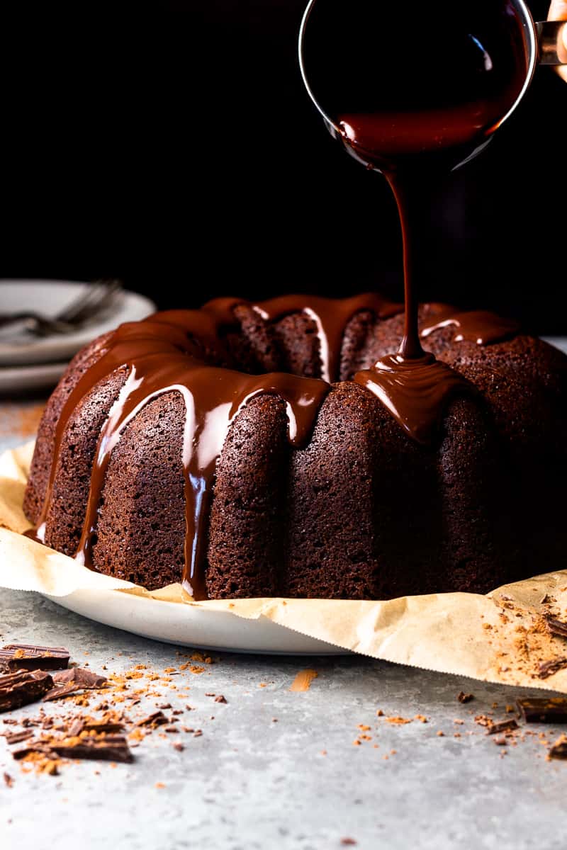 drizzling chocolate ganache over brownie cake