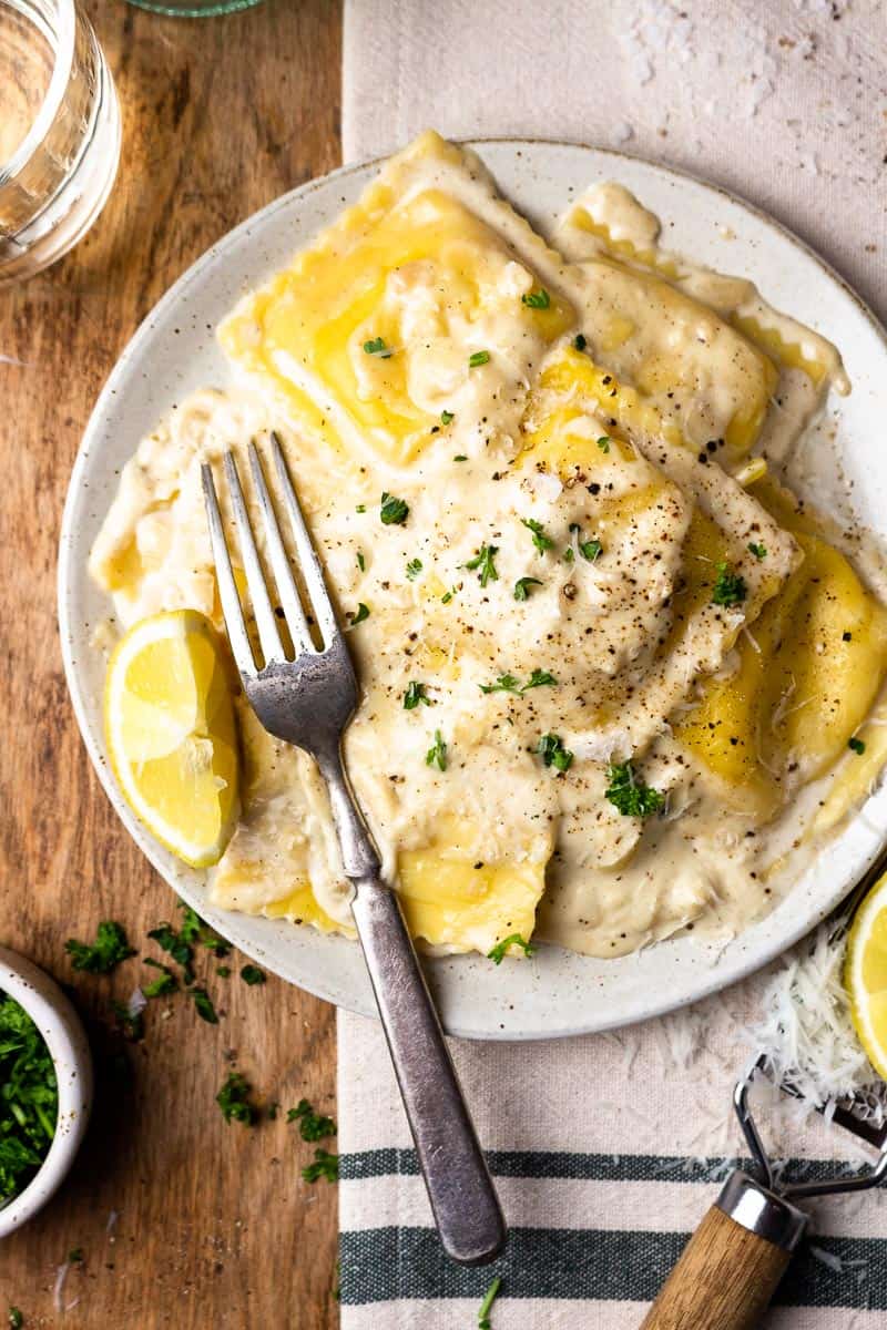 lobster ravioli and lemon cream sauce on a plate and garnished with parsley