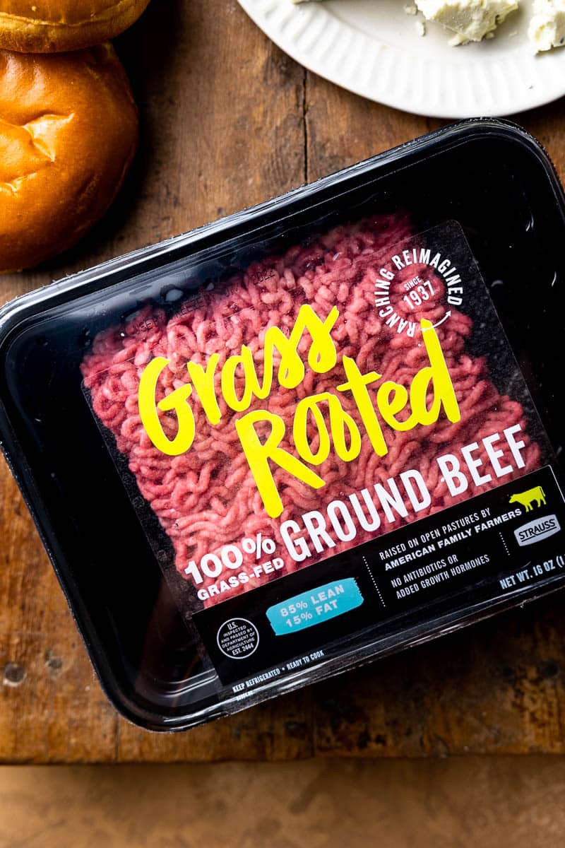 ground beef in packaging next to burger buns and blue cheese