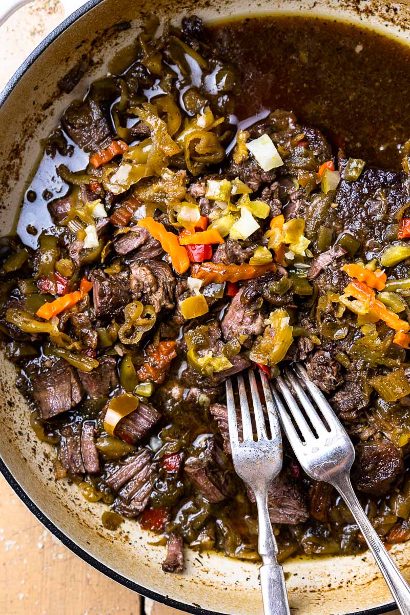 shredded Italian beef in skillet with two forks