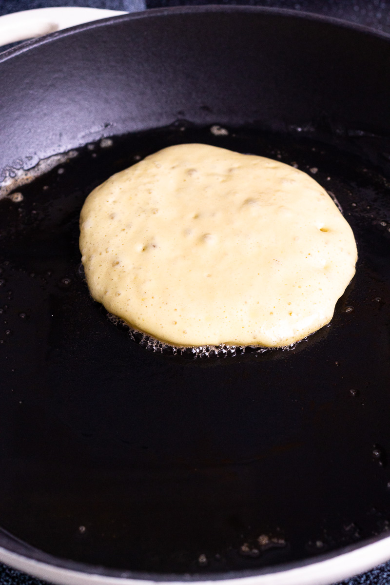 cooking a sourdough pancake in a skillet