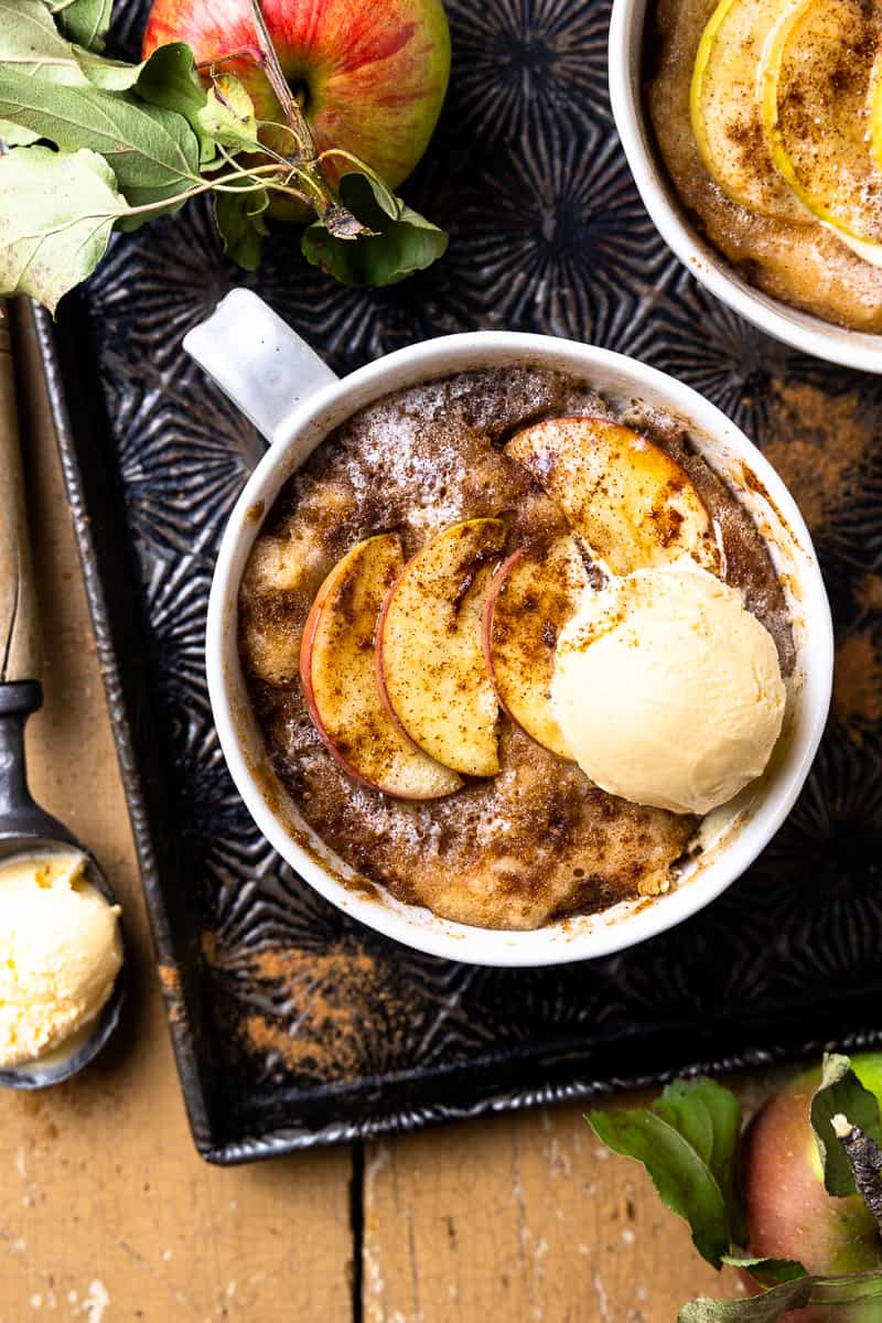 Cooked apple mug cake with a scoop of vanilla ice cream on top