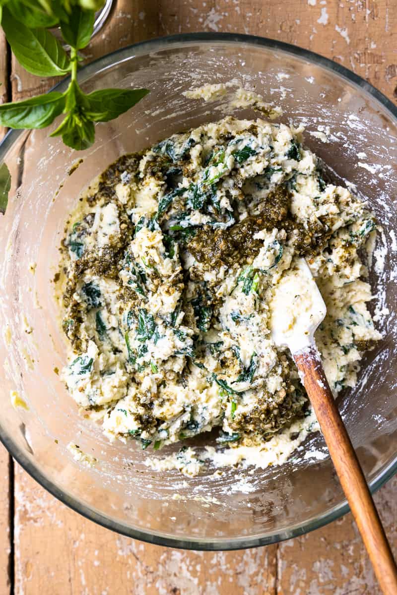 ricotta, mozzarella, parmesan, pesto, spinach and egg mixed together in a bowl