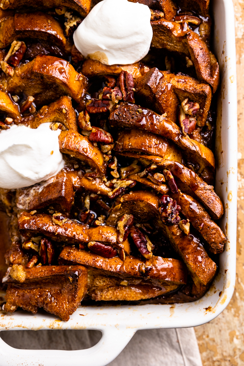 close up of hot buttered rum French toast bake topped with whipped cream