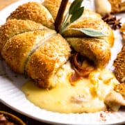 Puff pastry shaped pumpkin filled with brie cheese, pumpkin butter and pecans cut open