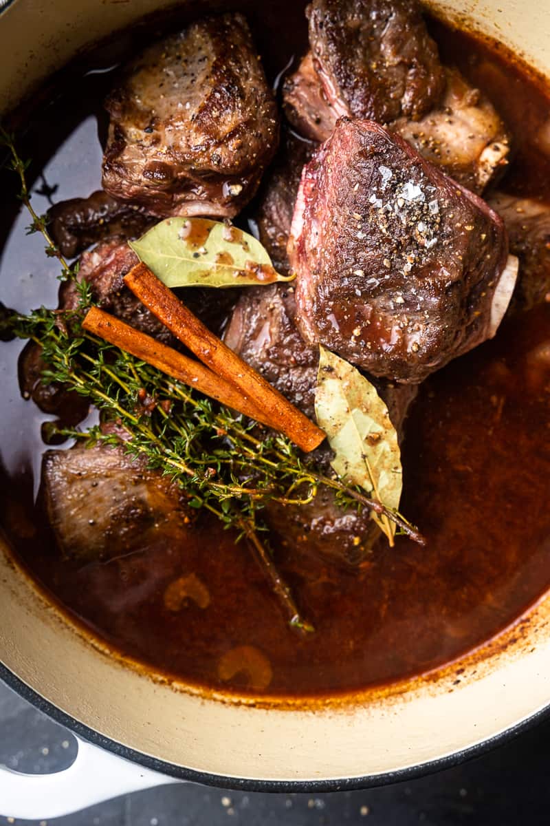 Bison short ribs in a pot with braising liquid