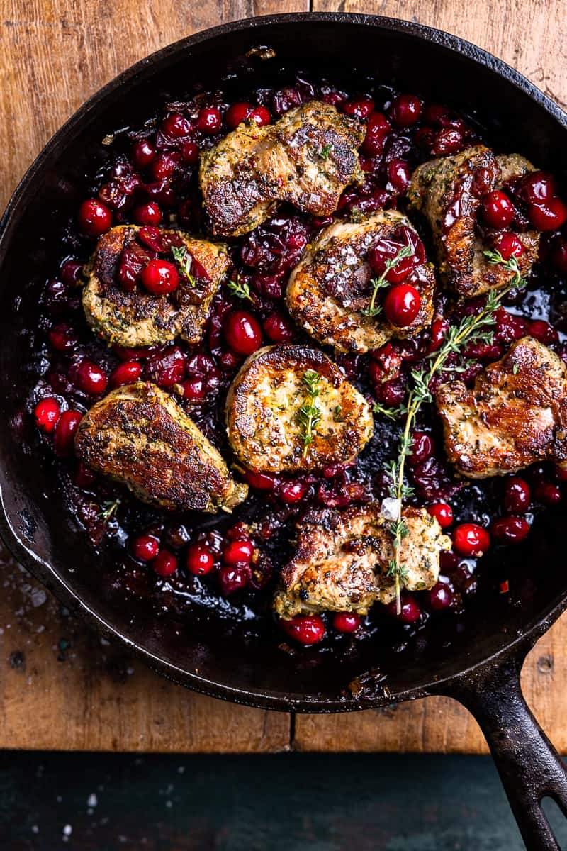 pork tenderloin medallions in a skillet with cranberry sauce and fresh thyme