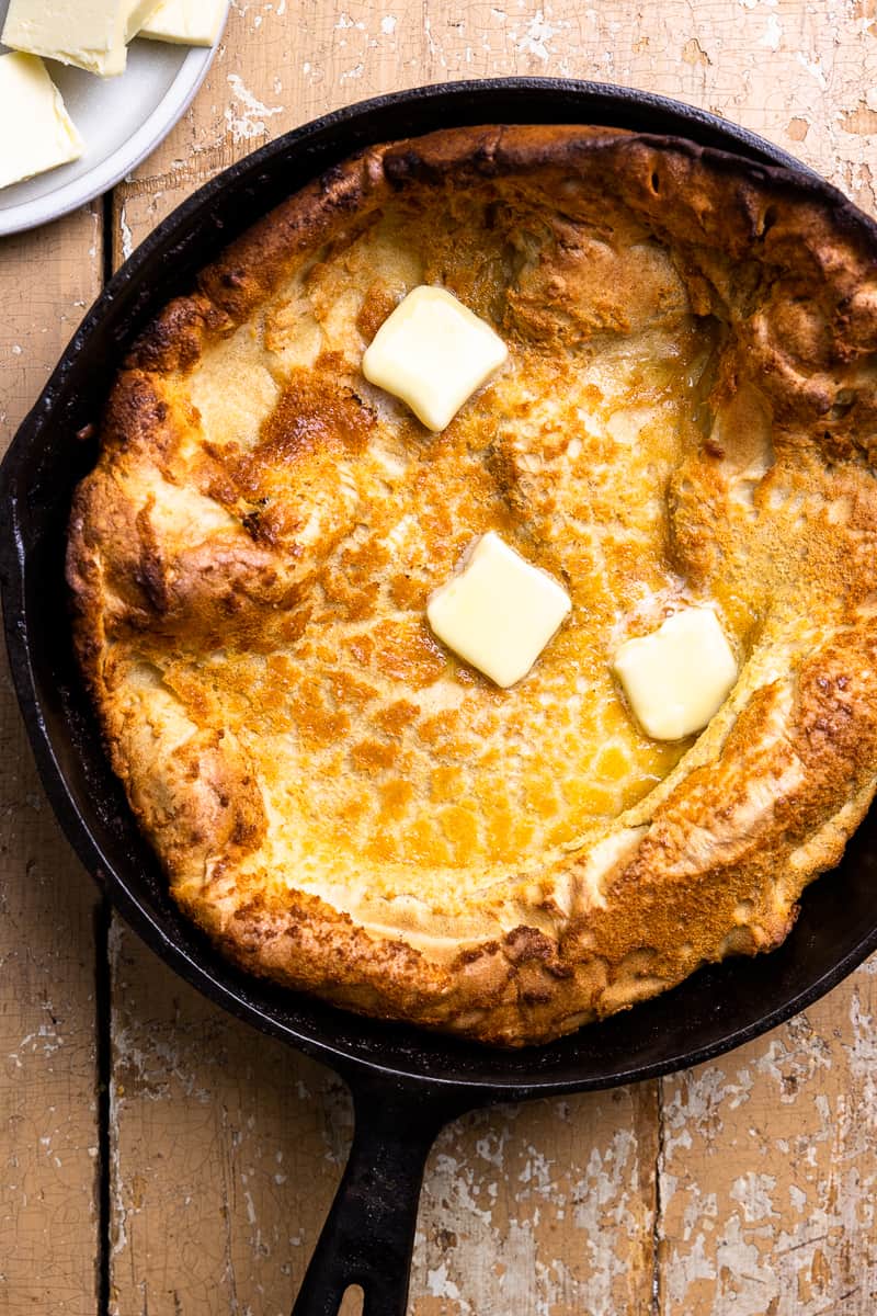 dutch baby in a skillet topped with butter