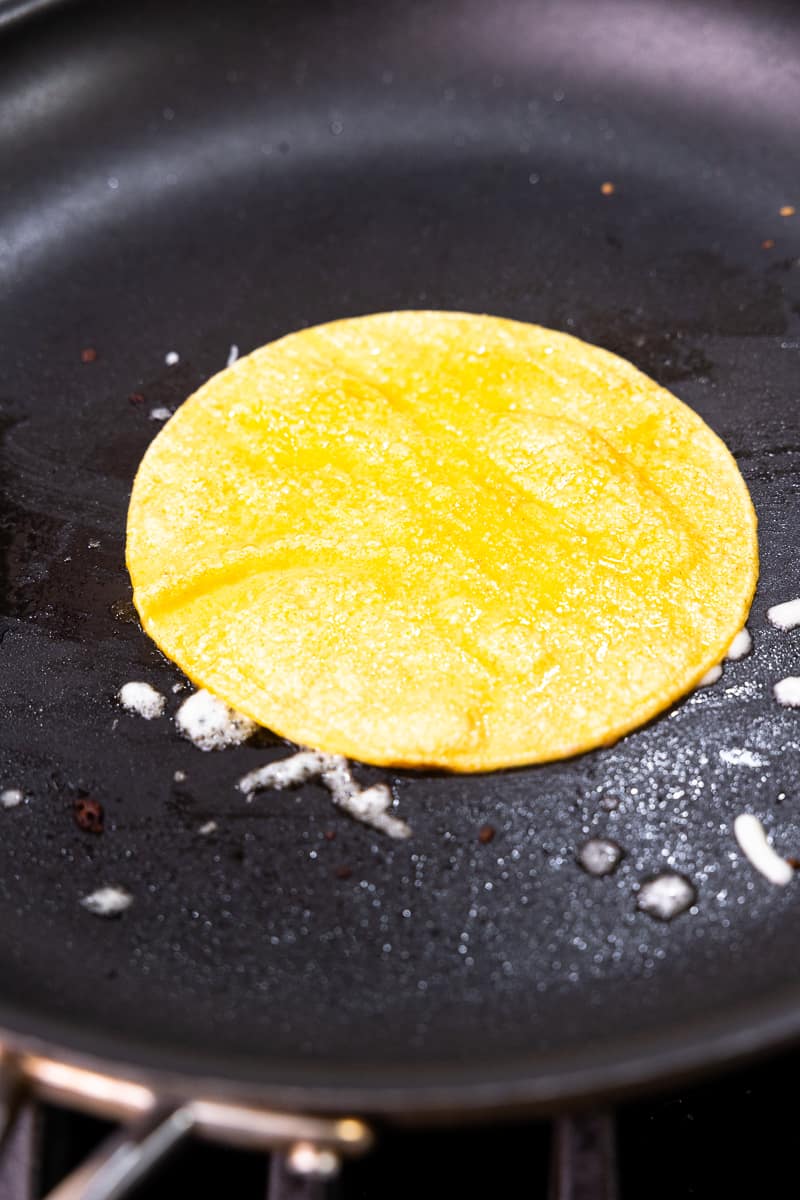 tortilla in a skillet over shredded cheese