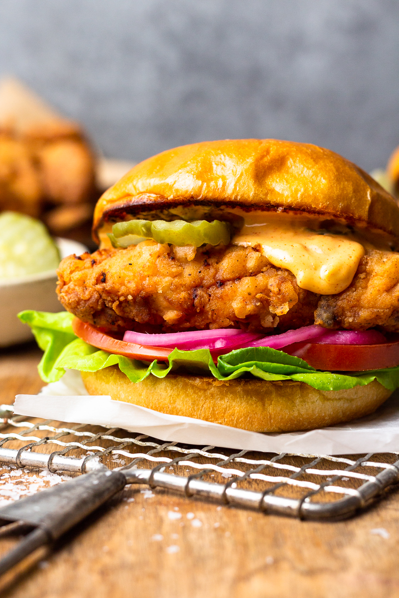 crispy fried chicken served on a bun with aioli and burger toppings