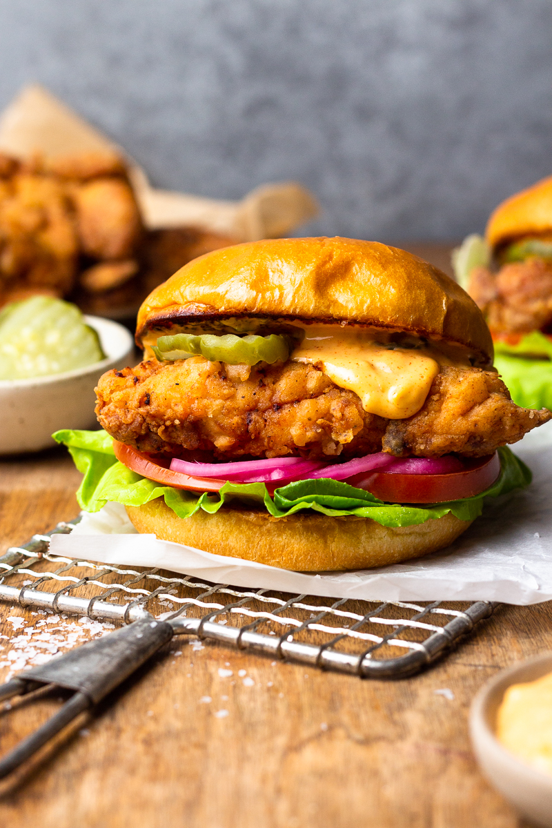 crispy fried chicken served on a bun with aioli and burger toppings