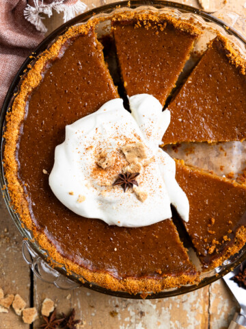 pumpkin pie with graham cracker crust topped with whipped cream
