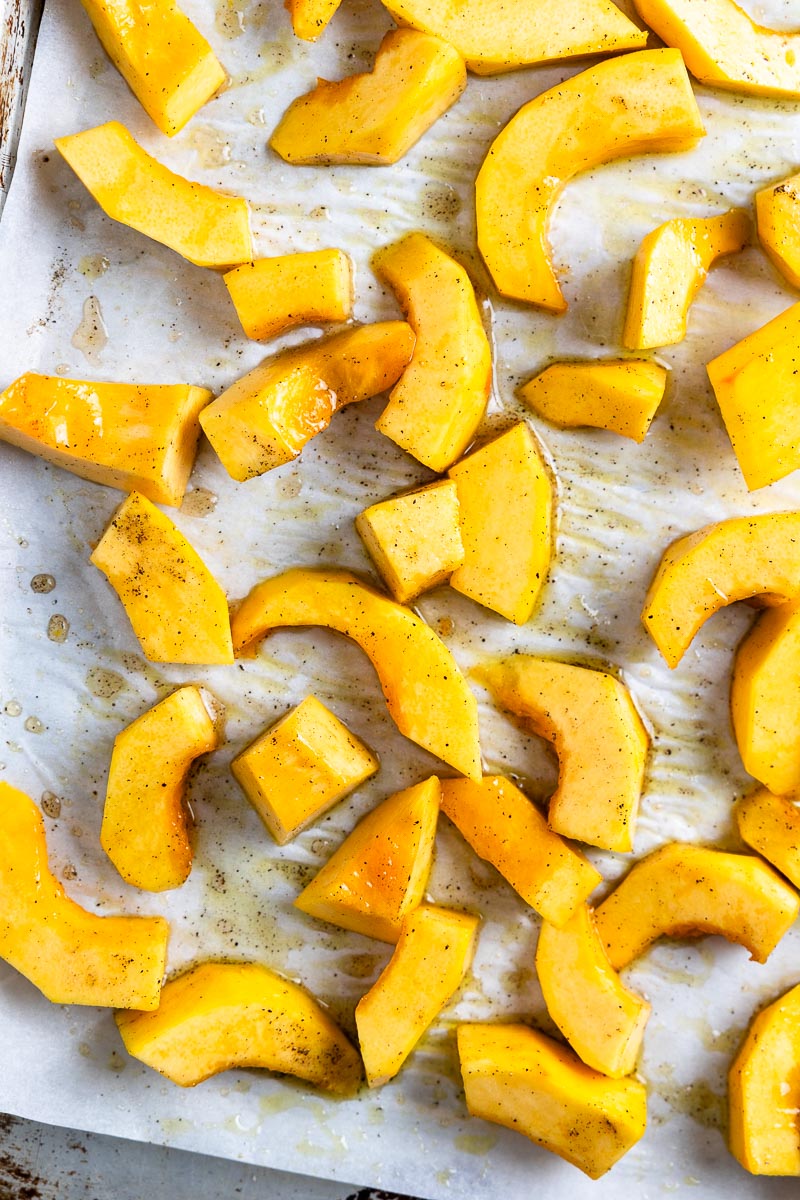 diced pumpkin on a baking sheet and tossed with olive oil, salt and pepper