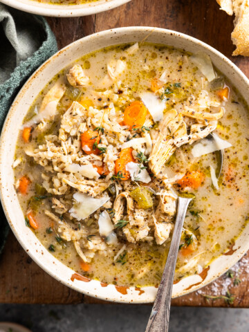 bowl of chicken and brown rice soup in a bowl and served with crusty bread