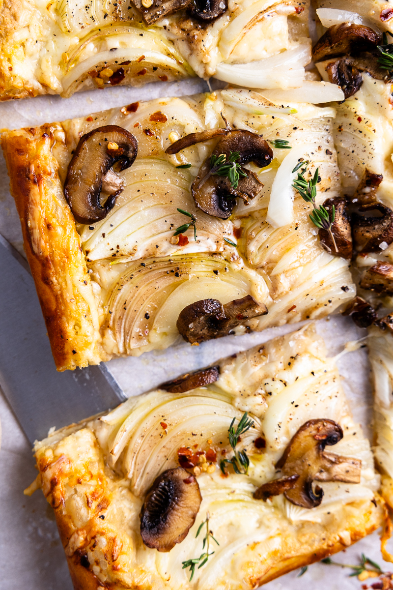 baked onion and mushroom puff pastry tart garnished with fresh thyme