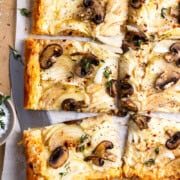 baked onion and mushroom puff pastry tart garnished with fresh thyme and sea salt, then cut into 6 pieces