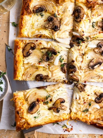 baked onion and mushroom puff pastry tart garnished with fresh thyme and sea salt, then cut into 6 pieces