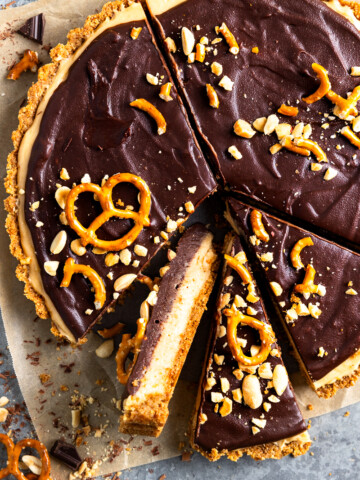 peanut butter pretzel pie cut into slices with one slice turned on its side to show layers