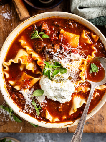 lasagna soup in a bowl topped with whipped pesto cottage cheese