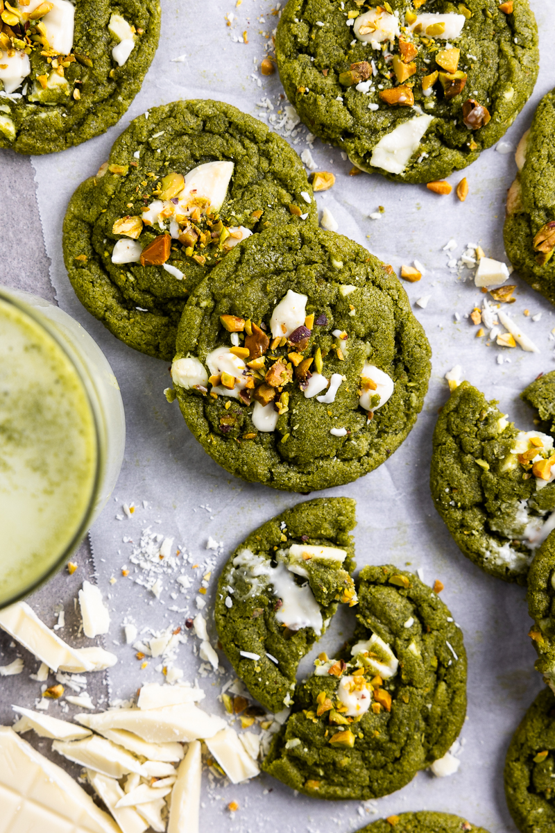 matcha cookies on parchment paper next to a matcha latte
