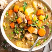 Chicken stew in a bowl served with white wine and crusty bread