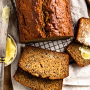 sliced sourdough banana bread on a cutting board with a butter dish