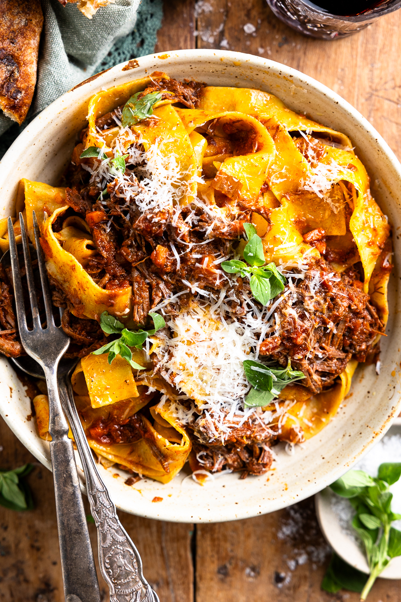 venison ragu served in a pasta bowl with pasta and parmesan cheese